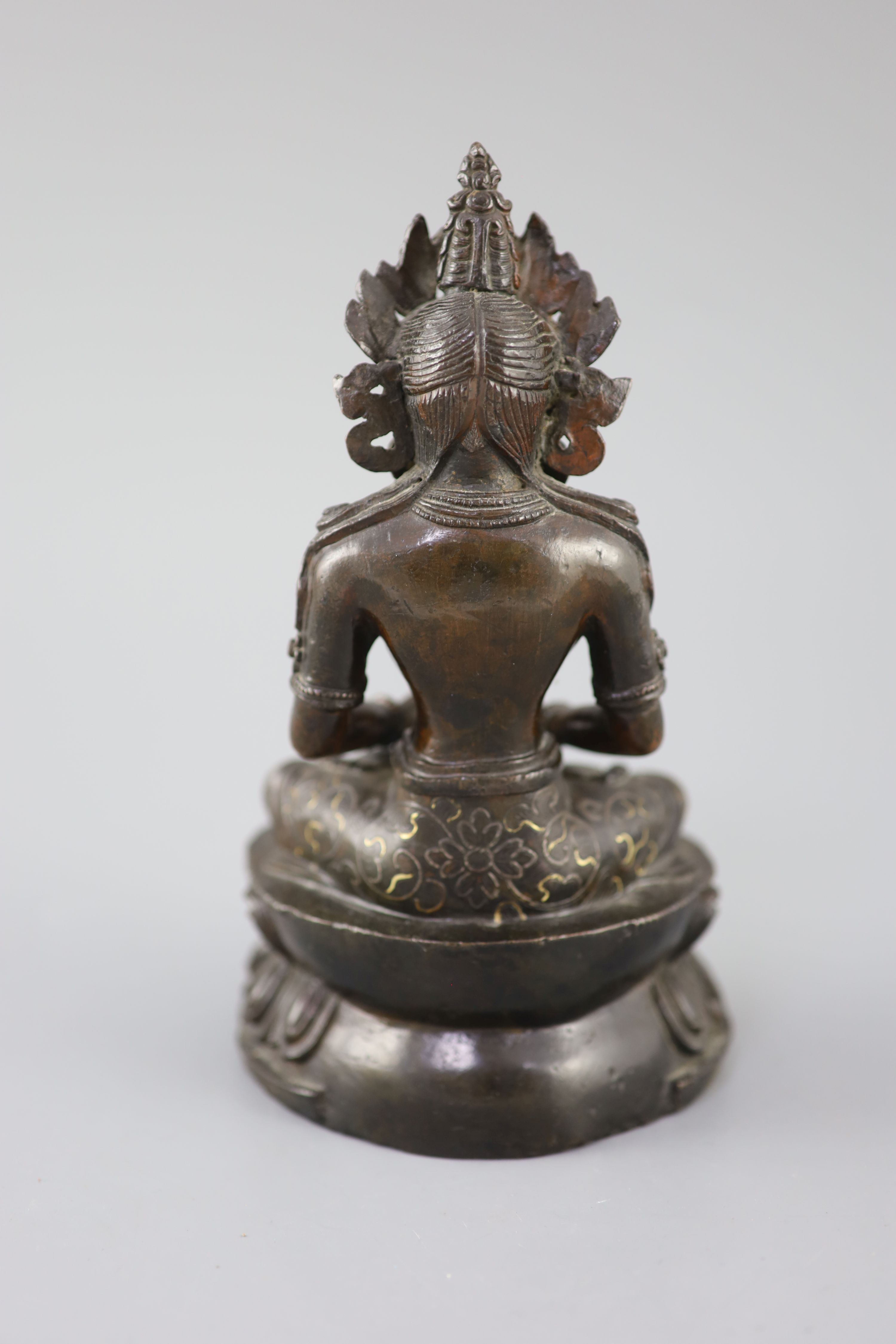 A Tibetan silver and gold inlaid copper alloy figure of Amitayus/Amitabha, c.15th century, 20.5cm high